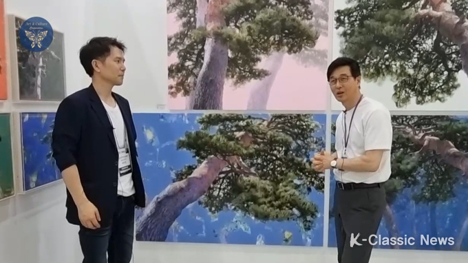사진=류명렬 작가(우)가 장인보 감독에게 소나무 작품에 대해 설명하고 있다