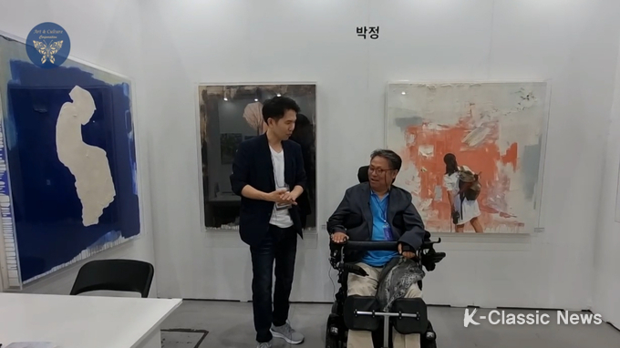 사진=박정 작가(우)가 장인보 감독에게 작품에 대해 설명하고 있다