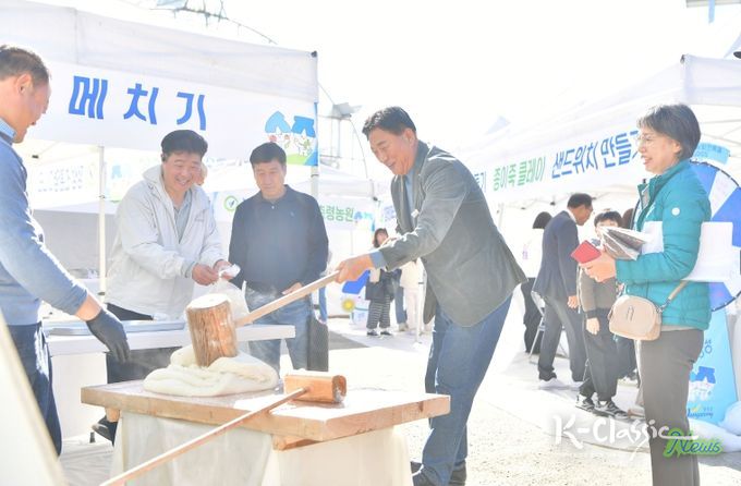 지난 15일 황룡면 팜파티 현장을 방문한 김한종 장성군수가 떡메치기 체험을 하고 있다.
